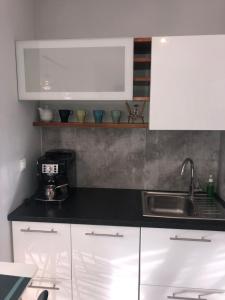 a kitchen with white cabinets and a sink at Apartamenty MAJA Nowy Targ in Nowy Targ