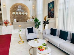 a living room with two couches and two tables at Hera Luxury Hotel in Ho Chi Minh City