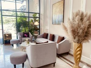 uma sala de estar com sofás e um vaso com uma planta em Hera Luxury Hotel em Ho Chi Minh