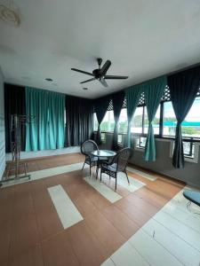 - un salon avec un ventilateur de plafond, une table et des chaises dans l'établissement Tokwan Homestay 2 - Homestay with private kid's pool, à Kuala Kedah