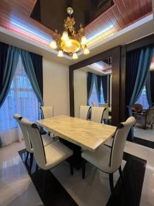 une table à manger avec des chaises et un grand miroir dans l'établissement Tokwan Homestay 2 - Homestay with private kid's pool, à Kuala Kedah