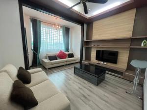 - un salon avec un canapé et une télévision dans l'établissement Tokwan Homestay 2 - Homestay with private kid's pool, à Kuala Kedah