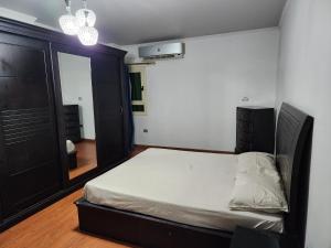 Dormitorio pequeño con cama y espejo en HOLIDAY VILLA 1 en El Cairo