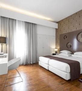 a bedroom with a large white bed and a desk at Hotel Tivoli Maputo in Maputo +47 photos