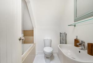 a white bathroom with a toilet and a sink at Historical and Quirky Home in Braintree