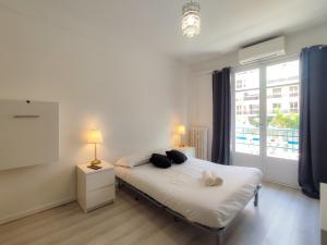 een slaapkamer met een bed met 2 lampen en een raam bij Stella Monte 3 A/C WiFi 2 Pers in Nice