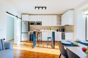 a kitchen with white cabinets and a table and chairs at Guest Inn 2 Boutique House in Lisbon