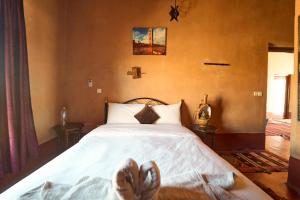 a bedroom with a bed with a cross on the wall at Chez Brahim vue panoramique in Aït Benhaddou