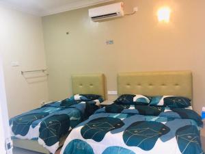dos camas sentadas una al lado de la otra en un dormitorio en Lang Buana Eco Park, en Jerantut