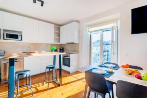 a kitchen and dining room with a table and chairs at Guest Inn 2 Boutique House in Lisbon