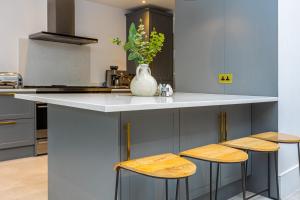 eine Küche mit einer Theke mit einer Vase darauf in der Unterkunft Stunning 5BR Home, SW London, 5 min Twickenham St in Twickenham