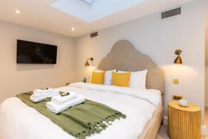 een slaapkamer met een bed met handdoeken erop bij Stunning 5BR Home, SW London, 5 min Twickenham St in Twickenham