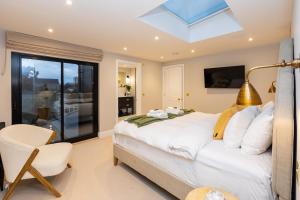 sypialnia z łóżkiem i świetlikiem w obiekcie Stunning 5BR Home, SW London, 5 min Twickenham St w mieście Twickenham