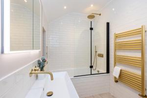baño blanco con ducha y lavamanos en Stunning 5BR Home, SW London, 5 min Twickenham St, en Twickenham