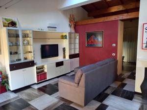 a living room with a couch and a tv at Ca' d Licio - Attico in Polinago