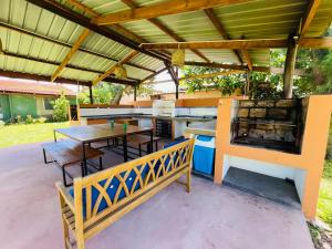un patio extérieur avec un barbecue, des tables et des chaises dans l'établissement Twin House #2, à Ponta do Ouro