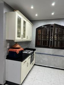 a kitchen with white cabinets and a stove at Holikeys - El jadida - 2 Ch - Sidi Bouzid 001 in El Jadida