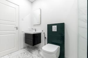 a white bathroom with a toilet and a sink at Vilnius legends house APARTMENT I Best for families I Free parking in Vilnius