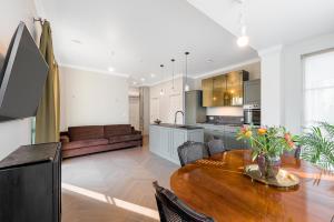 a kitchen and dining room with a wooden table at Vilnius legends house APARTMENT I Best for families I Free parking in Vilnius +5 photos