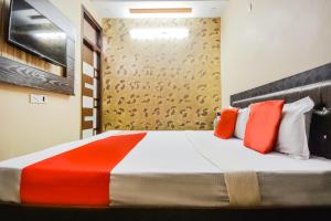 a bedroom with a bed with orange and white pillows at OYO Orange Residency in Chik Bānavar
