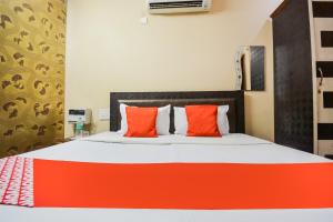 a bedroom with a bed with orange and white pillows at OYO Orange Residency in Chik Bānavar