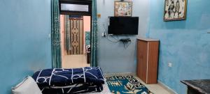 una camera con pareti blu e una porta con televisore di PRIYAMVADA FAMILY HOMESTAY a Vrindāvan