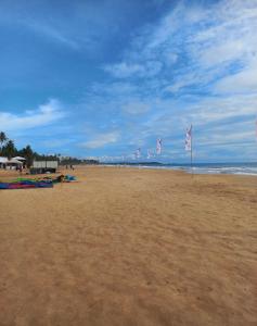 una playa con banderas en la arena y el océano en DR. Place en Hikkaduwa