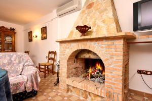 a brick fireplace in a room with a bed at Alojamiento La Nave de Zuheros in Zuheros