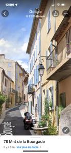 una moto conduciendo por una calle de la ciudad con edificios en Bed & Breakfast Les Hauts de Cagnes vue mer et montagne, en Cagnes-sur-Mer