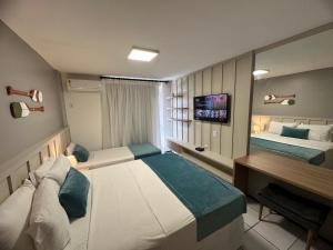 een hotelkamer met 2 bedden en een bureau bij Gran Lençois Flat in Barreirinhas