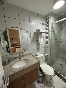 a bathroom with a toilet and a sink and a mirror at Gran Lençois Flat in Barreirinhas