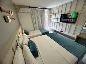 um quarto de hotel com uma cama e uma televisão em Gran Lençois Flat em Barreirinhas