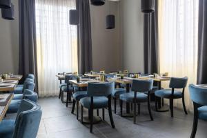 a restaurant with wooden tables and blue chairs at Flom Boutique Hotel in Florence