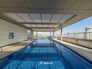 a swimming pool on the roof of a building at Manzil - 1BR plus Maid in Dubai Sports City in Dubai