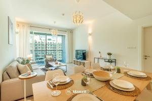 a living room with a table and a couch at Manzil - 1BR plus Maid in Dubai Sports City in Dubai