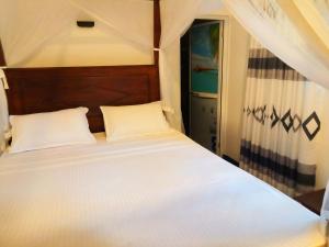 a bed with two white pillows in a bedroom at Opara Palace in Weligama