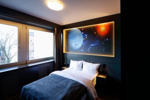 een slaapkamer met een bed en twee ramen met een planeet bij Sleephotels Cosmos in Hamburg