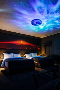 2 camas en una habitación con un mural de un planeta en Sleephotels Cosmos en Hamburgo