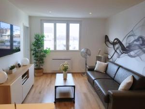 a living room with a couch and a table at Vue Montagne - Appt Cosy et calme - Netflix - Fibre in Grenoble