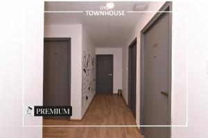 a hallway with a room with white walls and wooden floors at Townhouse Singapore Mall in Chinhat