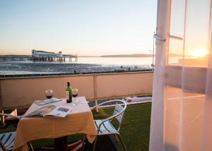 een tafel met wijnglazen en uitzicht op een pier bij Monaco Hotel in Weston-super-Mare
