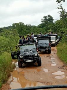 Un groupe de véhicules circulant sur un chemin de terre avec des gens à l'arrière dans l'établissement Kithmi Resort, à Polonnâruvâ