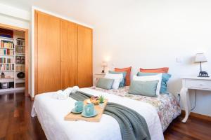 a bedroom with a bed with a tray of food on it at Homely Large Flat - Balcony in Guimarães