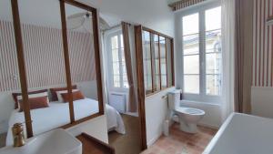 łazienka z łóżkiem, toaletą i umywalką w obiekcie Maison Charmeilles - La suite Fronsac w mieście Fronsac +22 zdjęcia