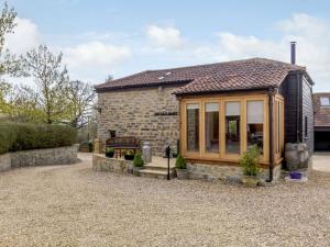 a small stone cottage with a large window at 1 Bed in Glastonbury 60295 in Ashcott