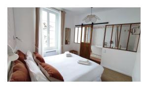 salon z białym łóżkiem i kanapą w obiekcie Maison Charmeilles - La suite Fronsac w mieście Fronsac