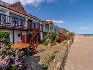 uma fila de casas na praia com uma mesa de madeira em 2 Bed in Bexhill-on-Sea 60137 em Bexhill