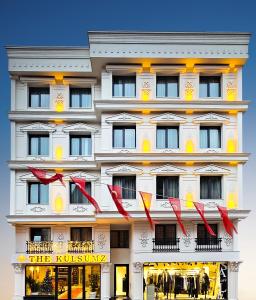 Un bâtiment blanc avec des archets rouges devant lui dans l'établissement The Külsümz Hotel, à Istanbul