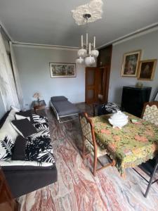 ein Wohnzimmer mit einem Tisch und einem Sofa in der Unterkunft Apartments Isi & Lory in Casalecchio di Reno