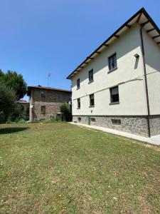 a large white building with a grass yard at Apartments Isi & Lory in Casalecchio di Reno